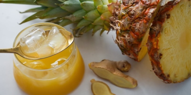 A glass of juice next to a pineapple AI-generated content may be incorrect.